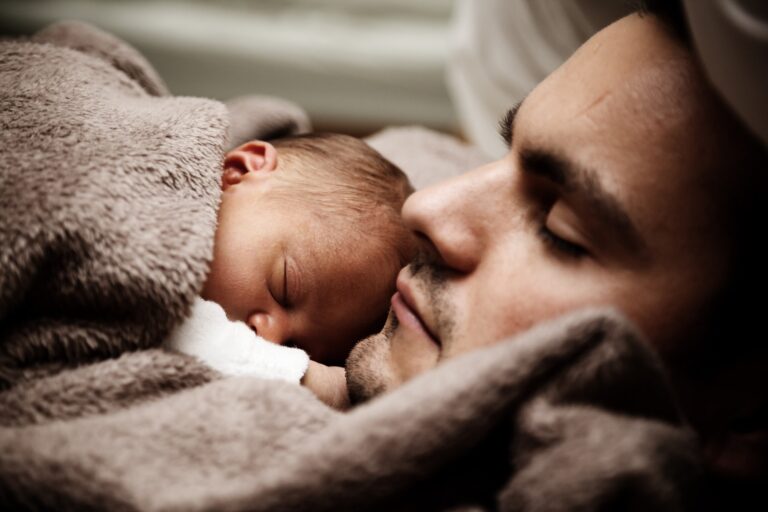 a father holding his sleeping baby
